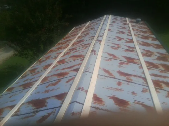 Rusted metal roof panels with new wood purlins before replacement — Storm Damage Roof Repair in Eads by Roofing Brothers