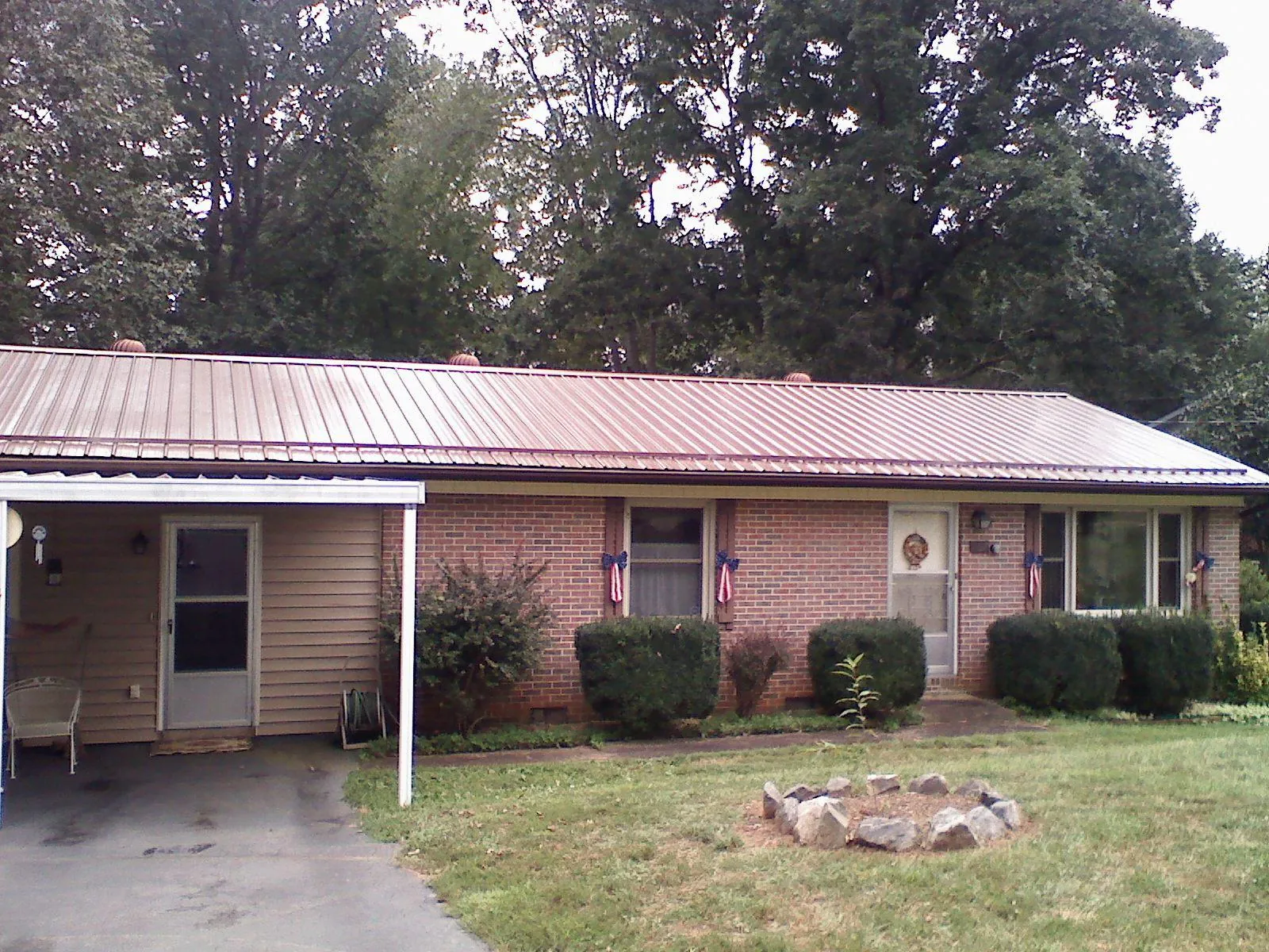 Bronze metal roof and carport on a brick ranch home — Roof Repair work by our crew in Eads